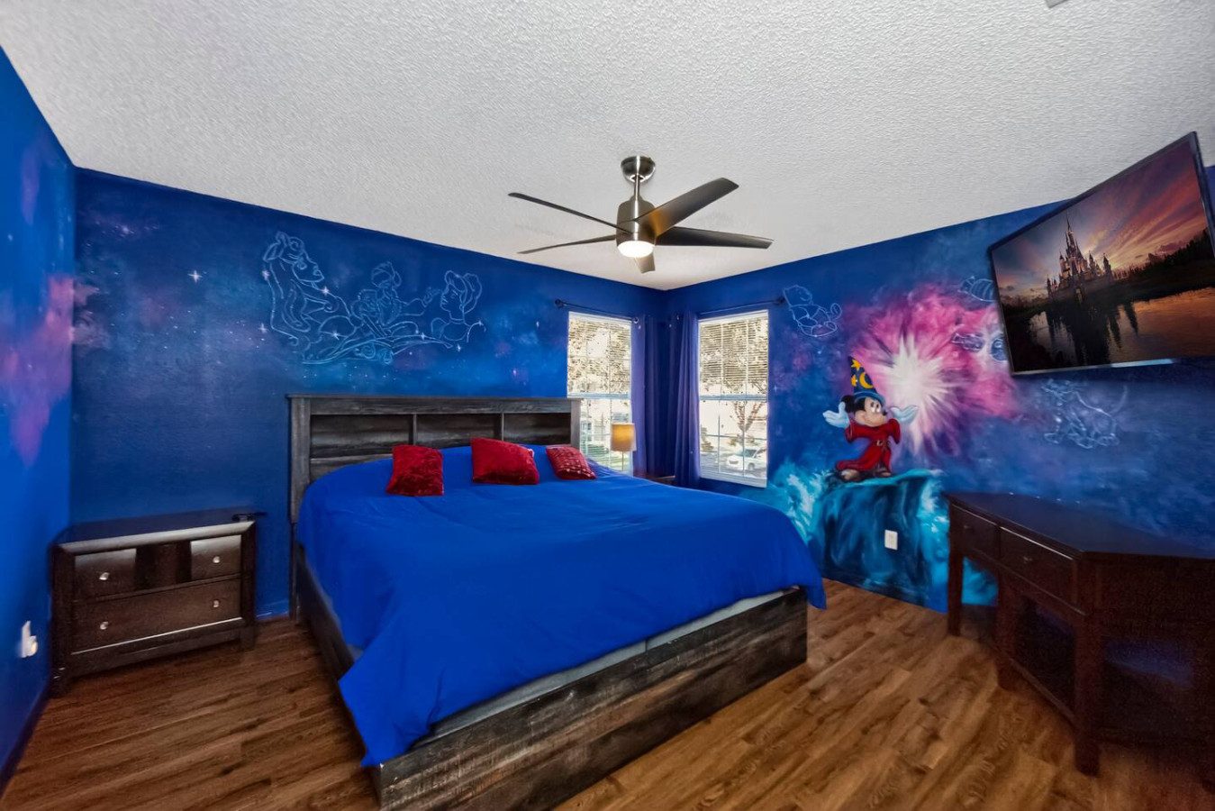 Um quarto com cama king de tema fantasia e uma parede com mural pintado à mão