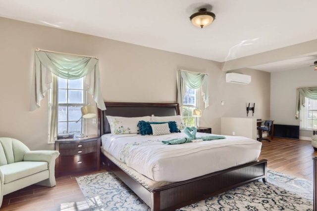 The Marvel Mansion, Master bedroom with king bed, work area, and ensuite private attached bathroom