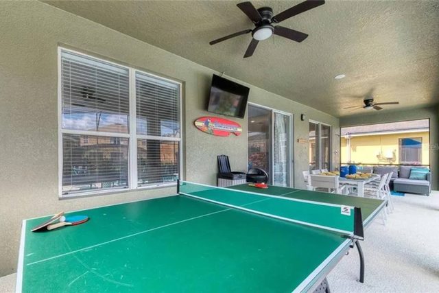 The Minion Mansion, Private pool with slide and covered lanai, lounge chairs, outdoor smart tv and outdoor dining with plenty of comfortable seating, and ping pong table.